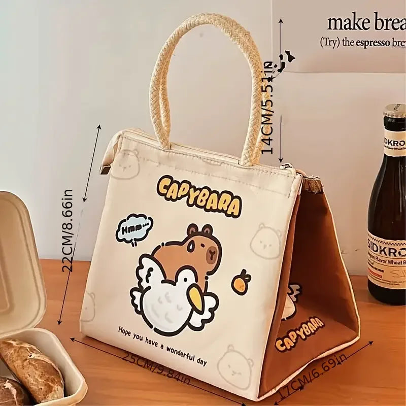 Kawaii capybara-themed tote bag with dimensions on a wooden surface next to a bottle of beer.