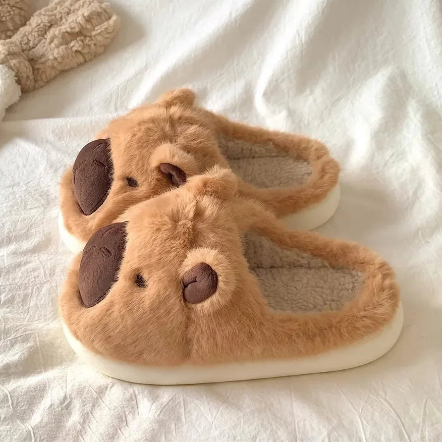 Pair of brown kawaii slippers with a face design on a white fabric background