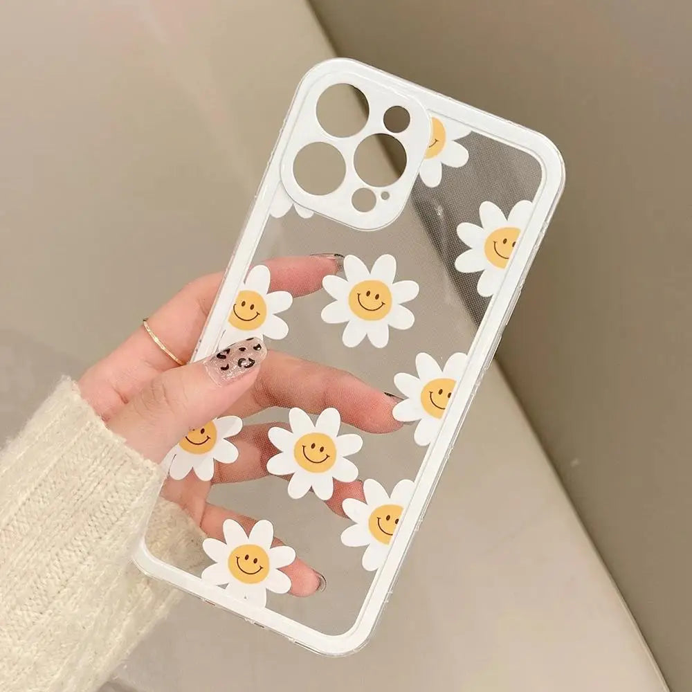 Clear phone case with kawaii smiley face daisy designs held by a hand against a neutral background