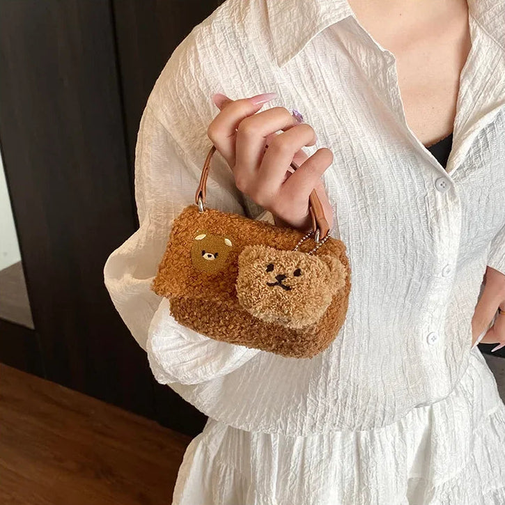 Person holding a Kawaii teddy bear-shaped handbag