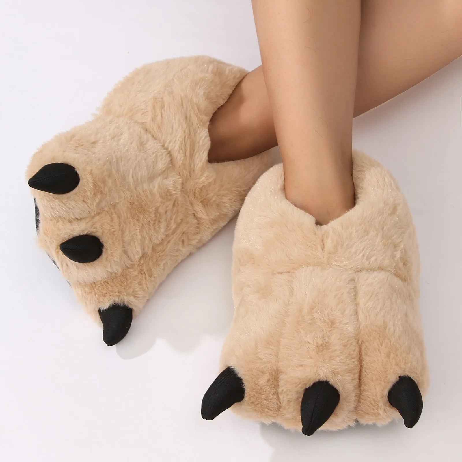 Beige paw-shaped kawaii slippers with black accents worn by a person on a white background