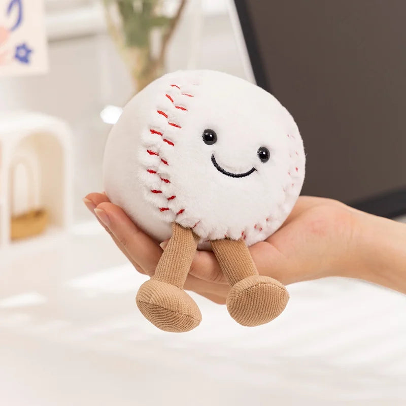 Plush kawaii toy baseball with legs and a face held in a hand