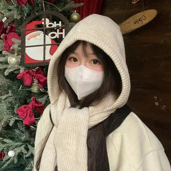 Person wearing a Kawaii white hooded coat and face mask in front of a decorated Christmas tree.