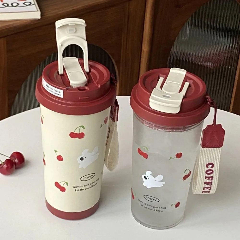 Two insulated travel mugs with Kawaii cherry and bear designs on a white surface.