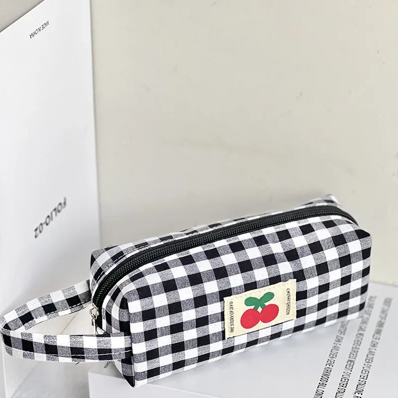 Black and white checkered kawaii pouch with a cherry label on a light gray background
