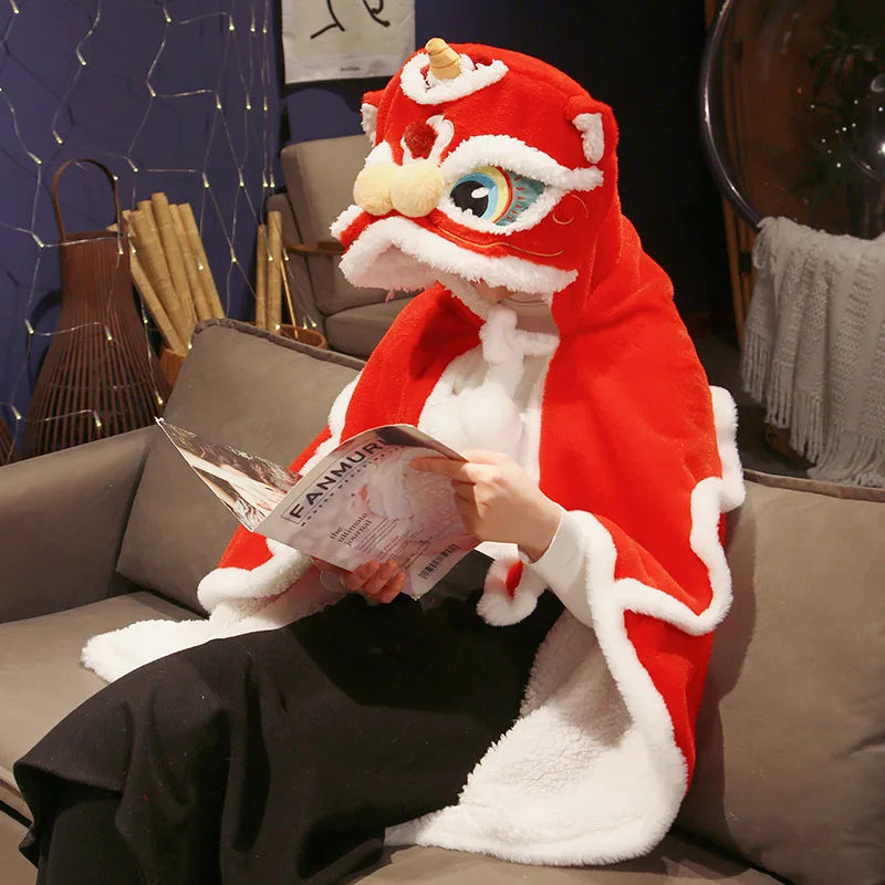 Person in a red and white dragon kawaii costume reading a magazine on a couch.