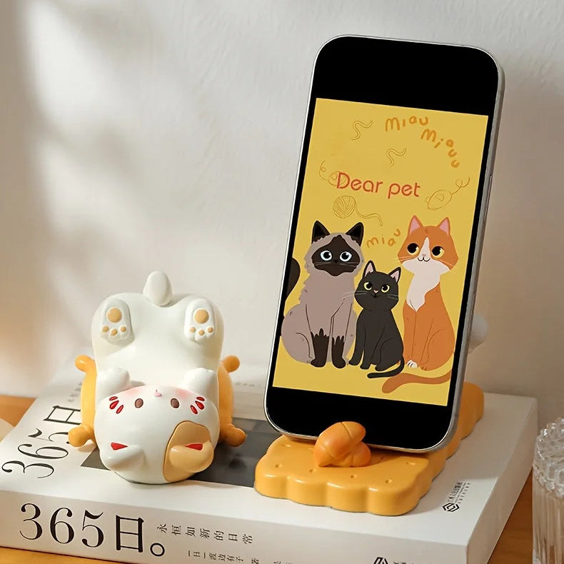 Kawaii phone stand with cartoon cat design on a book