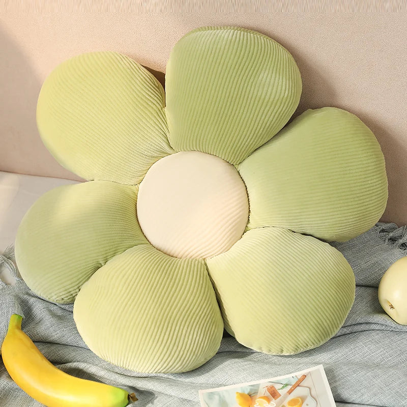 Kawaii flower-shaped pillow with ribbed texture on a bed with a banana and magazine.