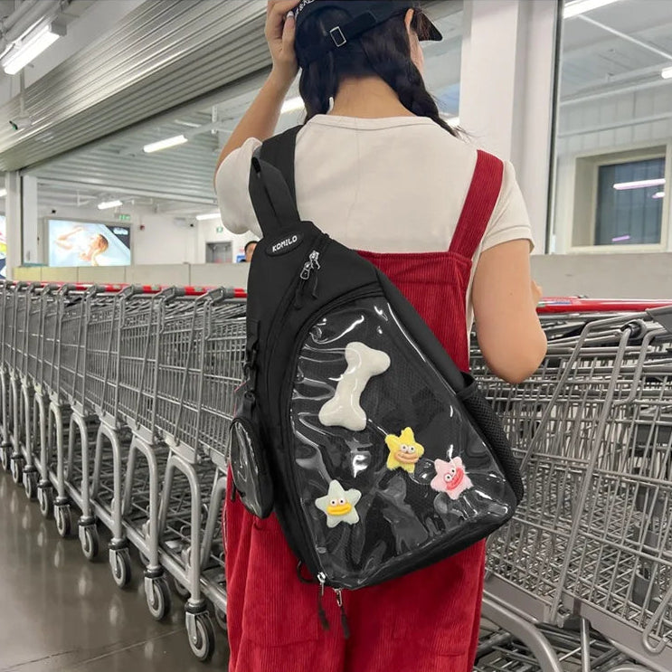 Person wearing a black Kawaii sling bag with cartoon designs in a shopping mall.