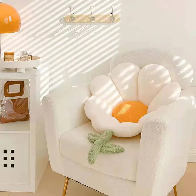 Kawaii flower-shaped cushion on a white chair in a room with a lamp and shelves.