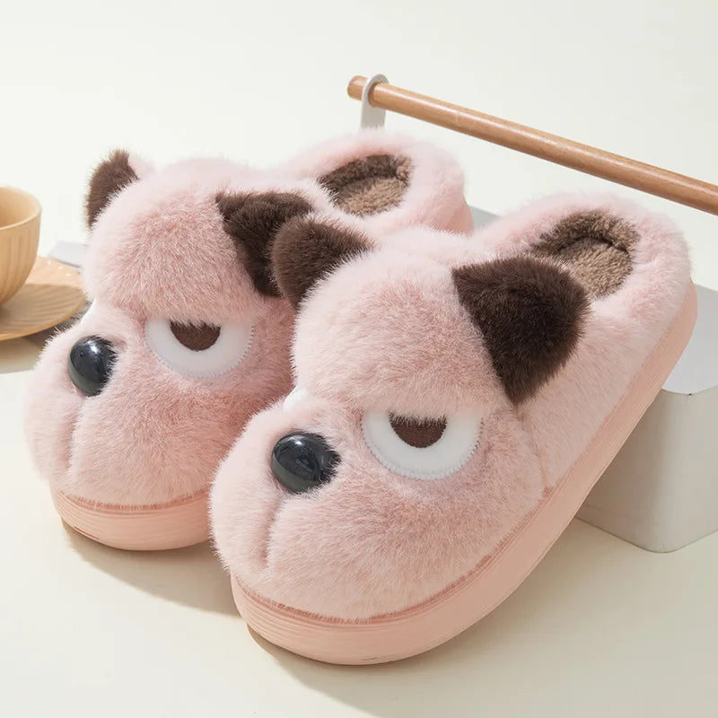Pair of pink slippers with kawaii bear face design on a light background
