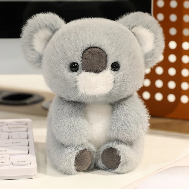 Plush kawaii toy koala on a desk with office items in the background