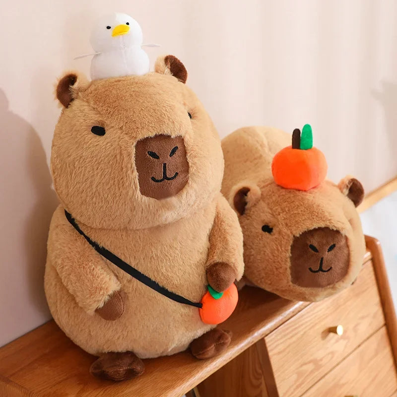 Two plush kawaii toys resembling beavers with a duck on one of them, sitting on a wooden surface.