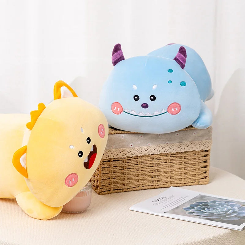 Two cute kawaii plush toys, one yellow and one blue with purple horns, on a white surface.