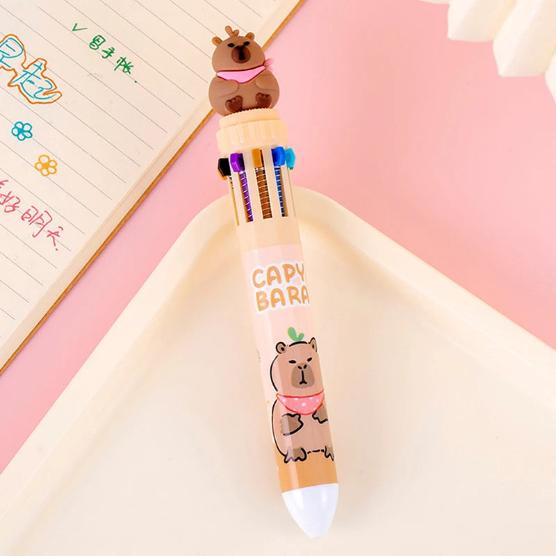 Kawaii capybara-themed pen with multiple colored pens on a pink background