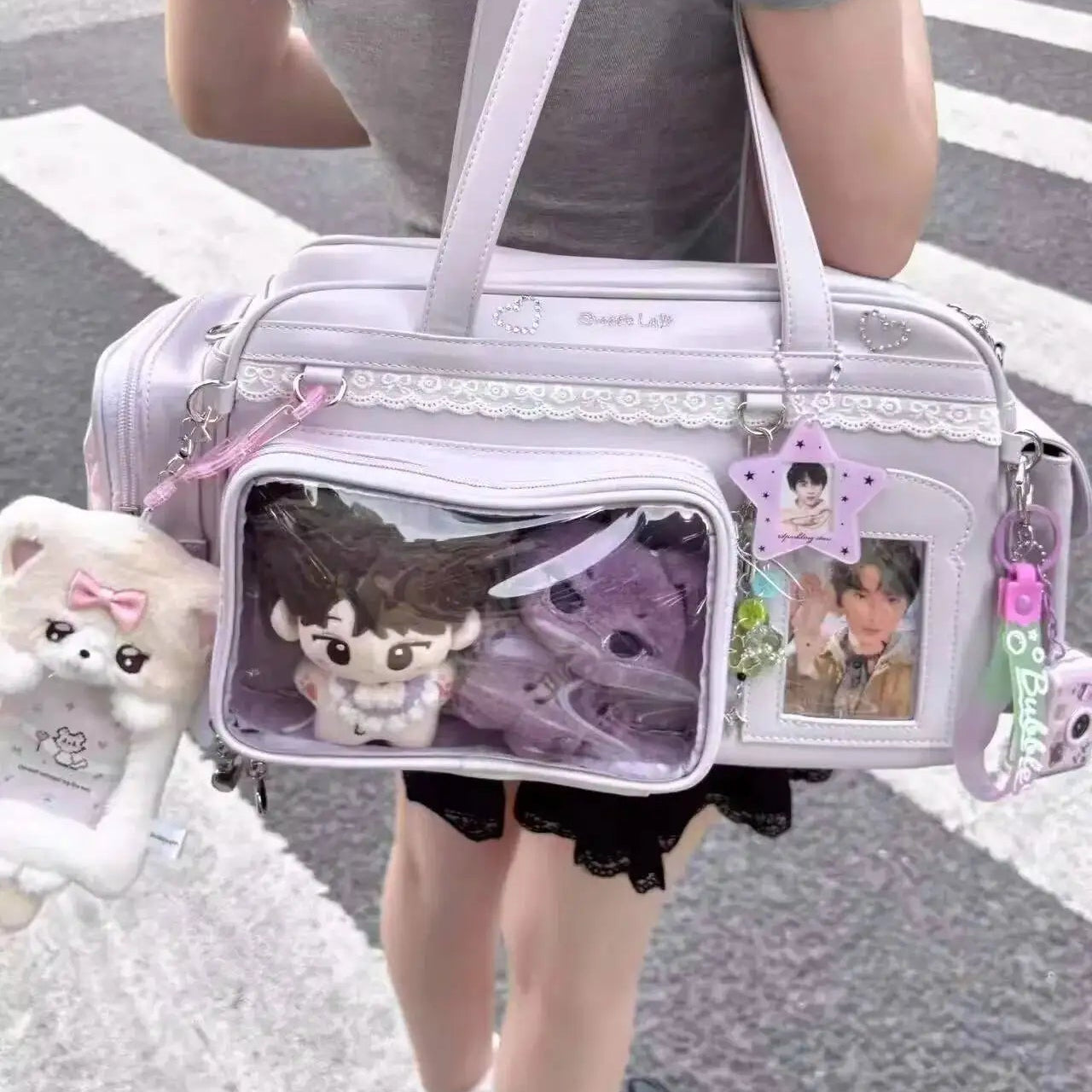 Person carrying a decorative Kawaii handbag with plush toys and photos on a street.