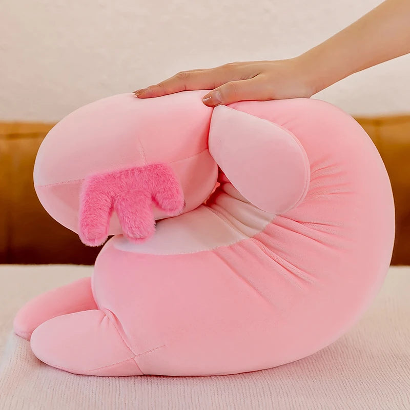 Pink plush animal-shaped kawaii pillow with a hand on a light pink background