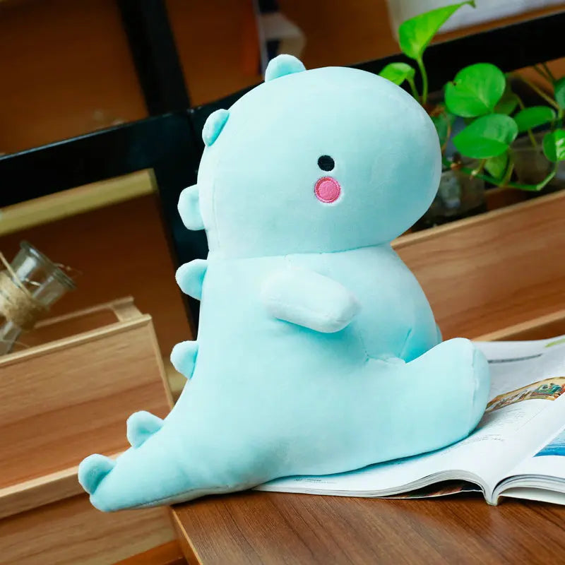 Light blue kawaii plush toy with a happy expression on a wooden surface.