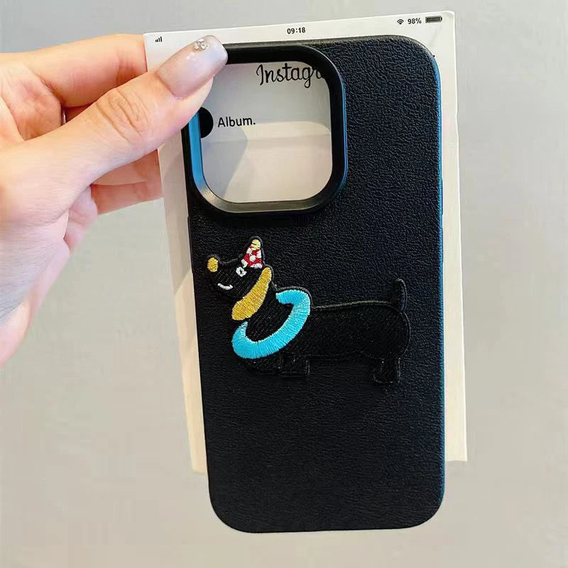 Black phone case with kawaii cartoon design held by a hand on a gray background