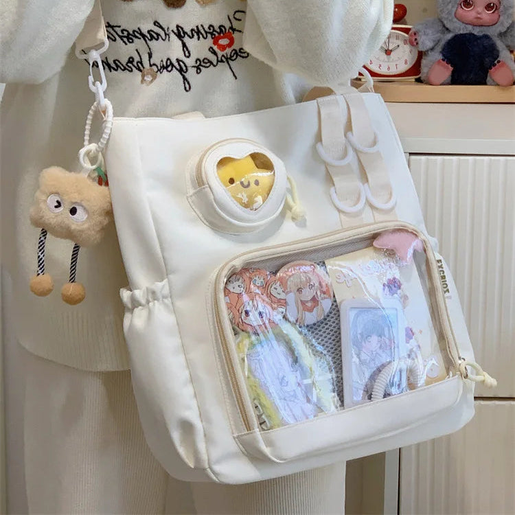 White Kawaii backpack with cartoon character design and bear charm, worn by a person.