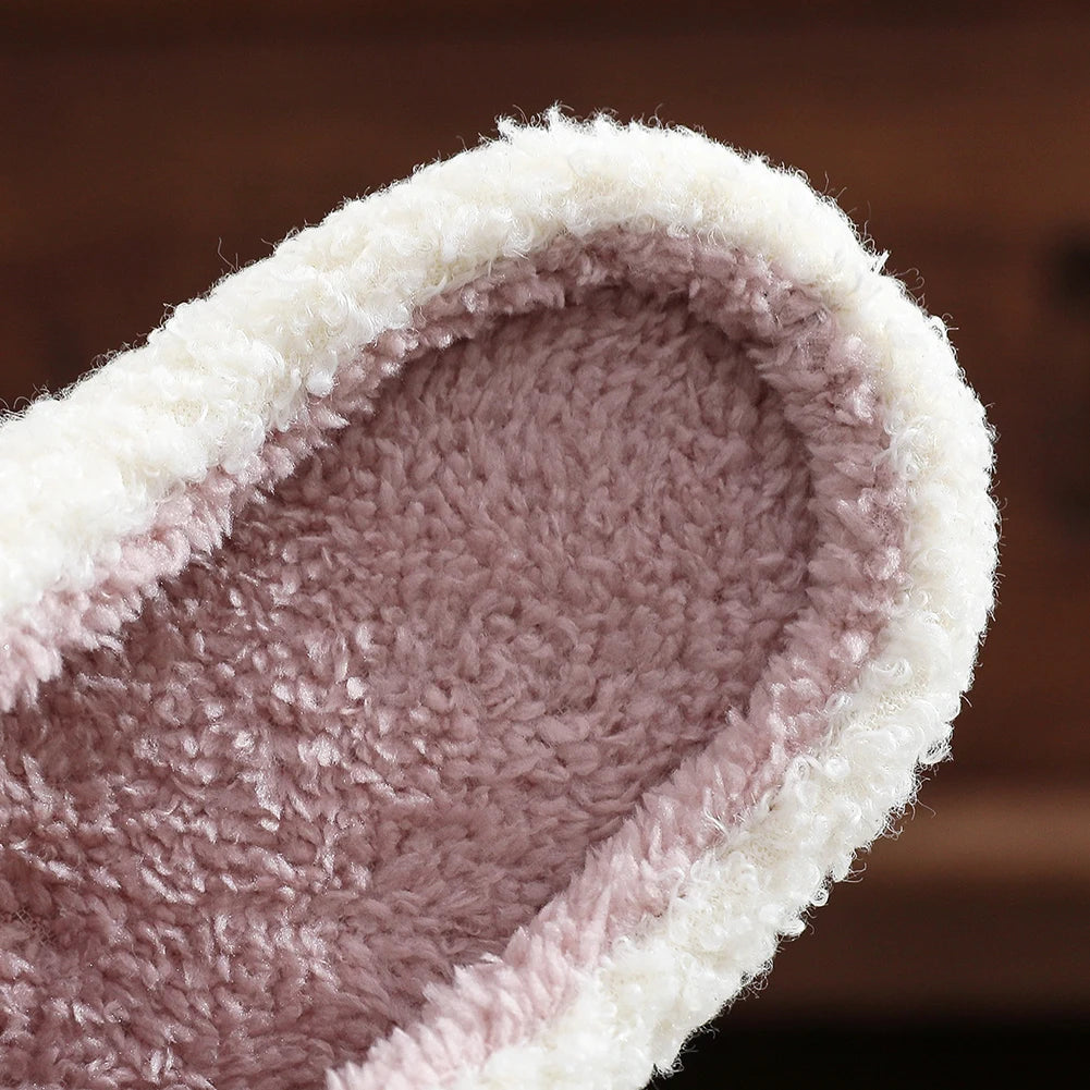 Close-up of a fluffy pink kawaii slipper with white trim on a blurred brown background