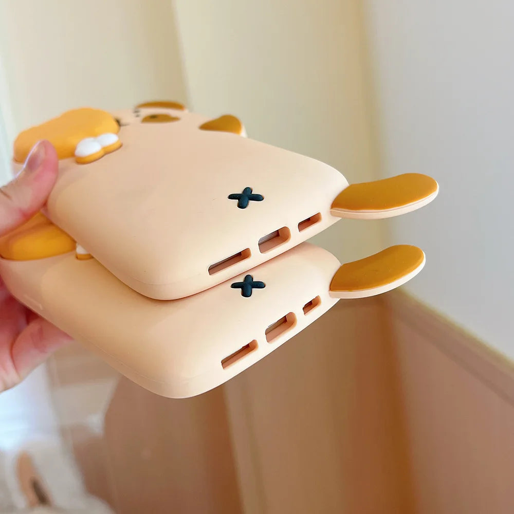 Kawaii cartoonish pink and yellow device held by a hand against a neutral background