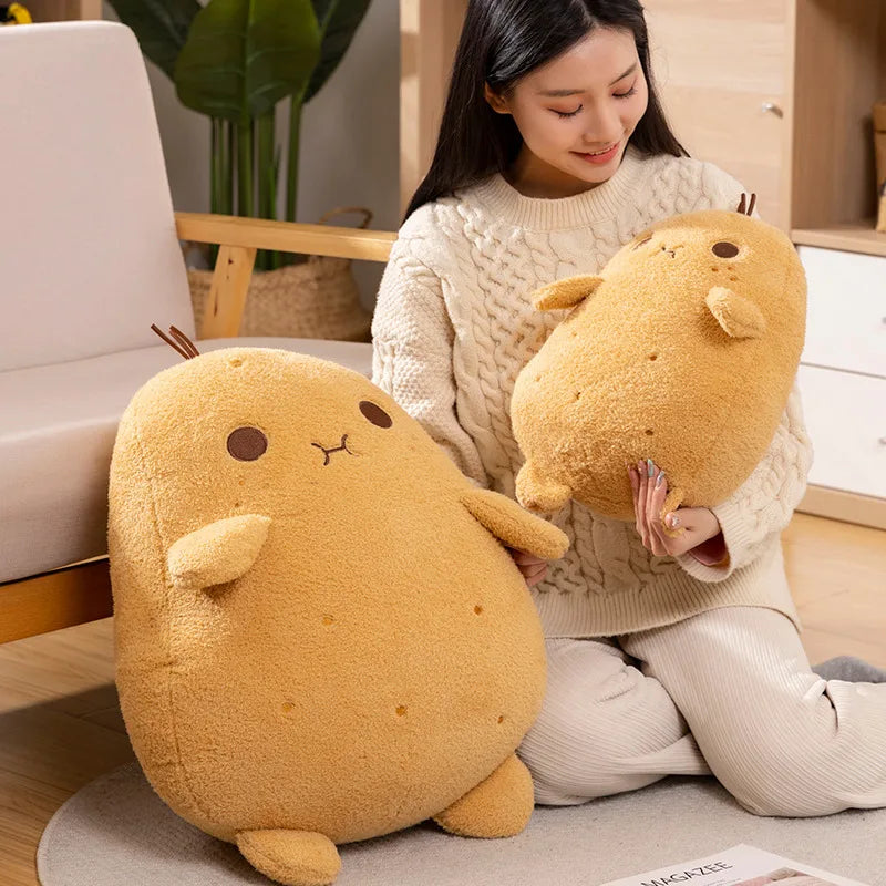 Woman holding two large yellow kawaii plush toys resembling animals in a cozy indoor setting.