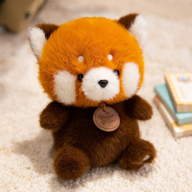 Plush kawaii toy red panda with a tag on a soft surface