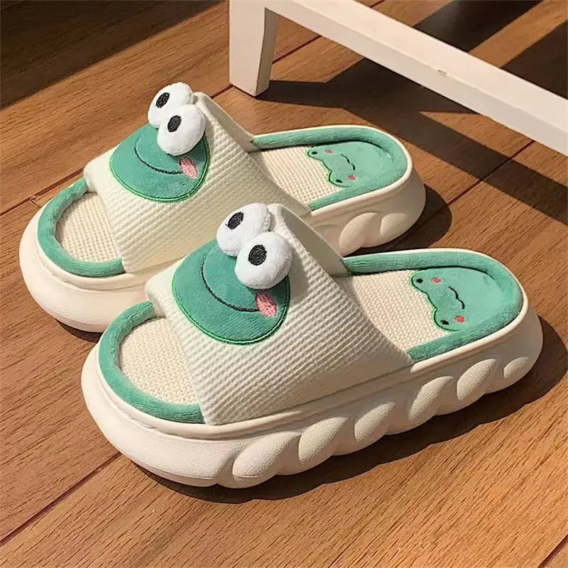 Pair of frog-themed kawaii slippers on a wooden floor