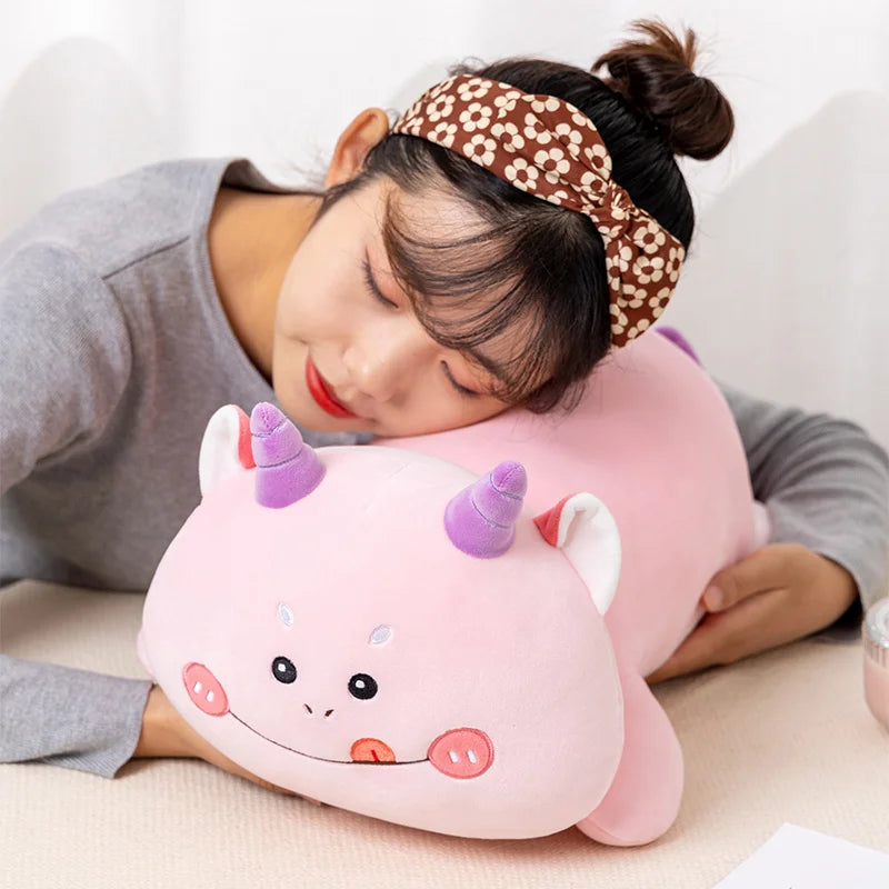 Person lying on a kawaii unicorn-shaped pillow with a headband on a light-colored surface