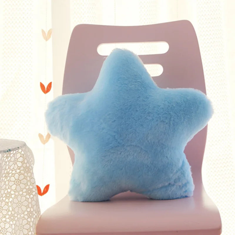 Blue star-shaped Kawaii pillow on a pink chair with a light background