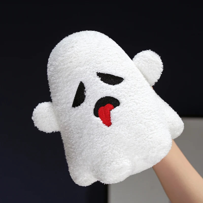 White ghost-shaped plush kawaii toy with black eyes and red tongue held by a hand against a dark background