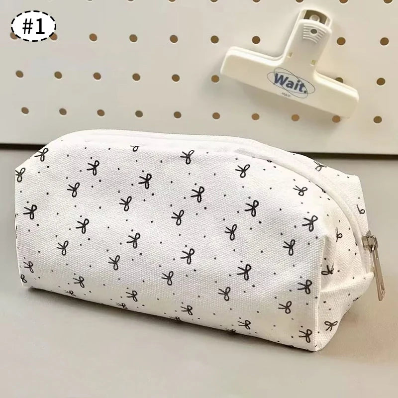 White kawaii pouch with black scissors pattern on a gray surface with a pegboard background