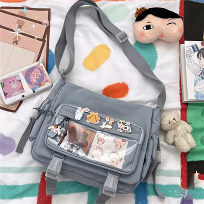 Gray Kawaii shoulder bag with decorative elements on a colorful blanket with toys and art supplies.
