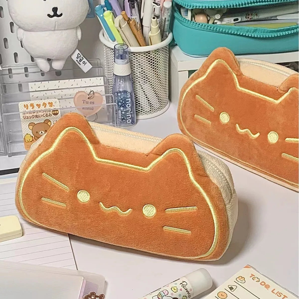 Cat-shaped kawaii pencil case on a desk with stationery items