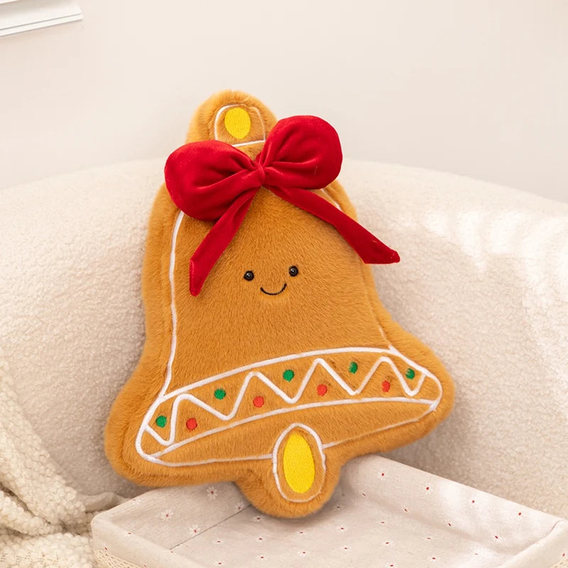 Gingerbread bell-shaped kawaii plush toy with a red bow on a soft surface