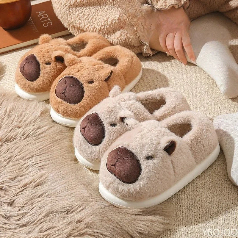 Pair of bear-shaped kawaii slippers on a soft surface with a blurred background