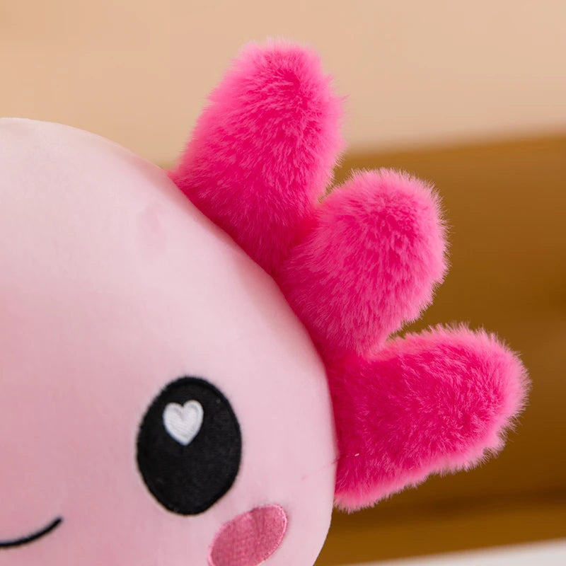 Close-up of a pink kawaii plush toy with a heart-shaped eye on a beige background