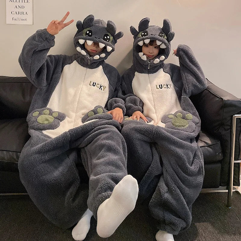 Two people wearing kawaii dragon-themed onesies sitting on a couch.
