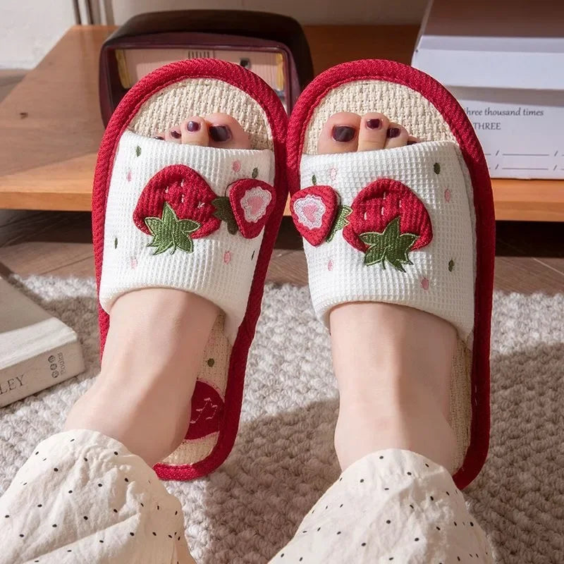 White slippers with red strawberry kawaii design worn indoors.