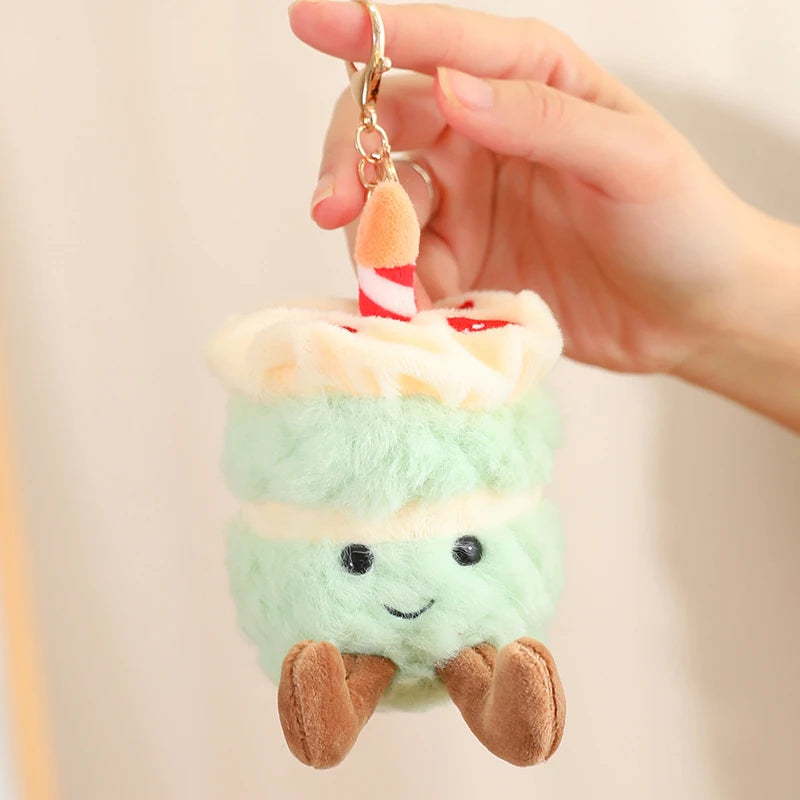 Plush kawaii keychain shaped like a layered dessert held by a hand against a neutral background