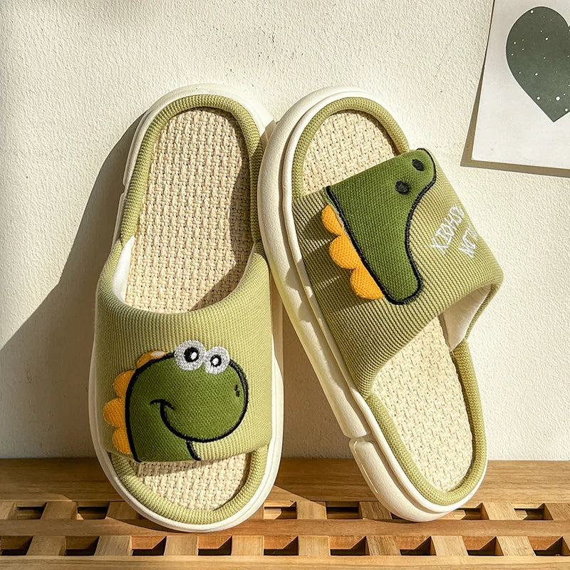 Green slippers with frog kawaii design on a wooden surface