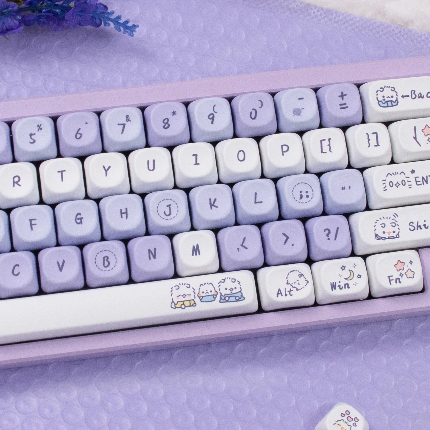 Keyboard with Kawaii character designs on keys against a matching purple background