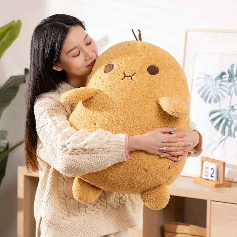 Person holding a large plush kawaii toy in a cozy indoor setting