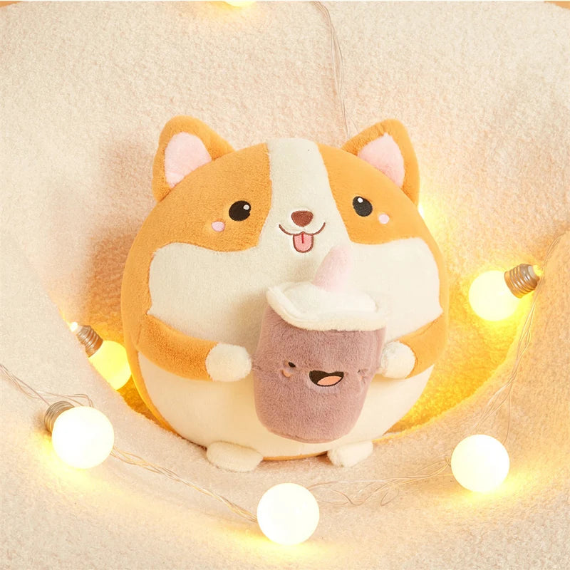 Plush kawaii toy of a corgi with a smaller plush toy inside, surrounded by string lights on a soft surface.