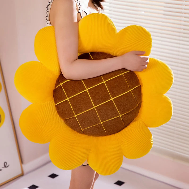 Person holding a sunflower-shaped kawaii pillow with a checkered center.