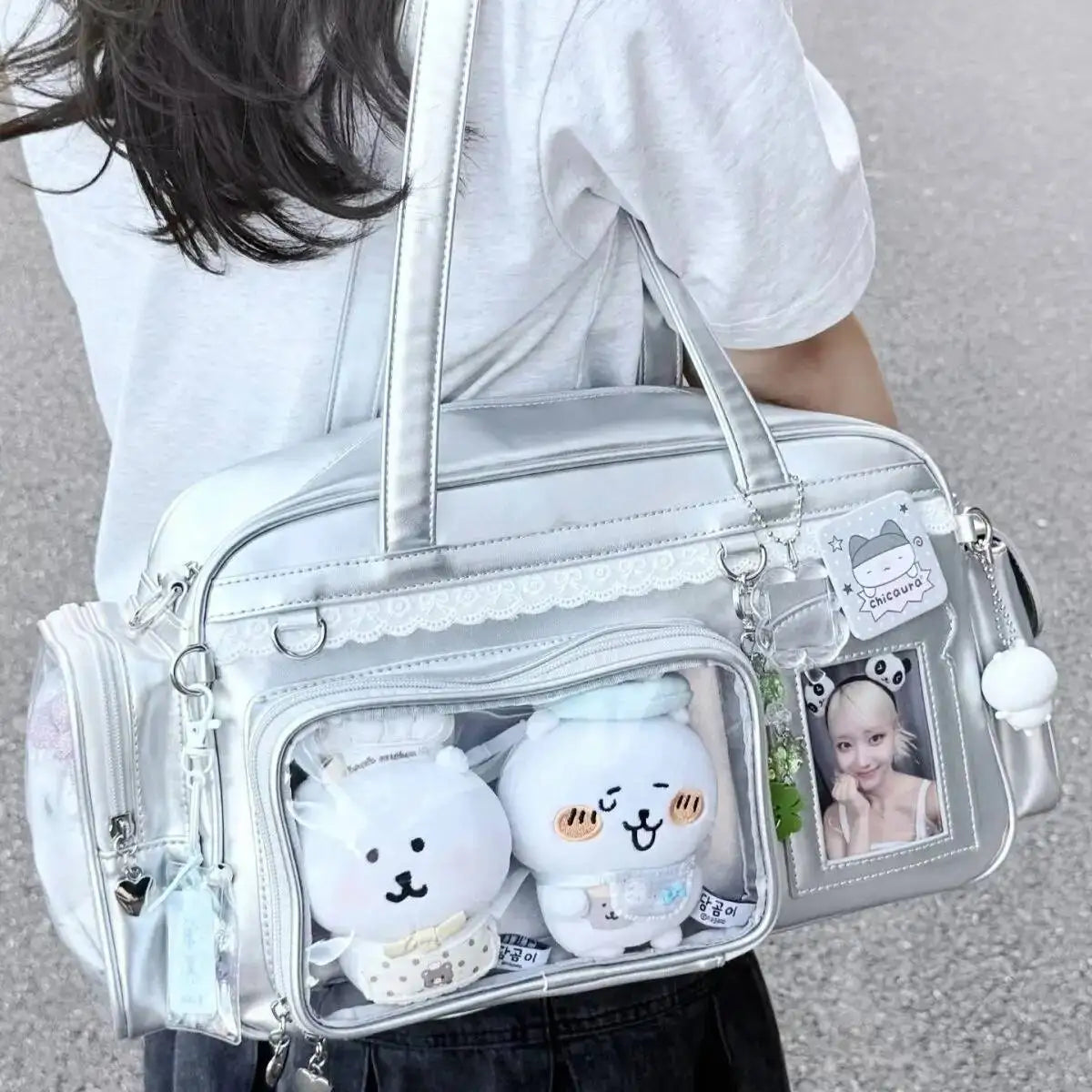 Clear Kawaii handbag with cartoon character plushies and a photo frame on a neutral background