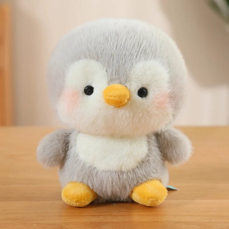 Plush kawaii toy penguin on a wooden surface with a blurred background