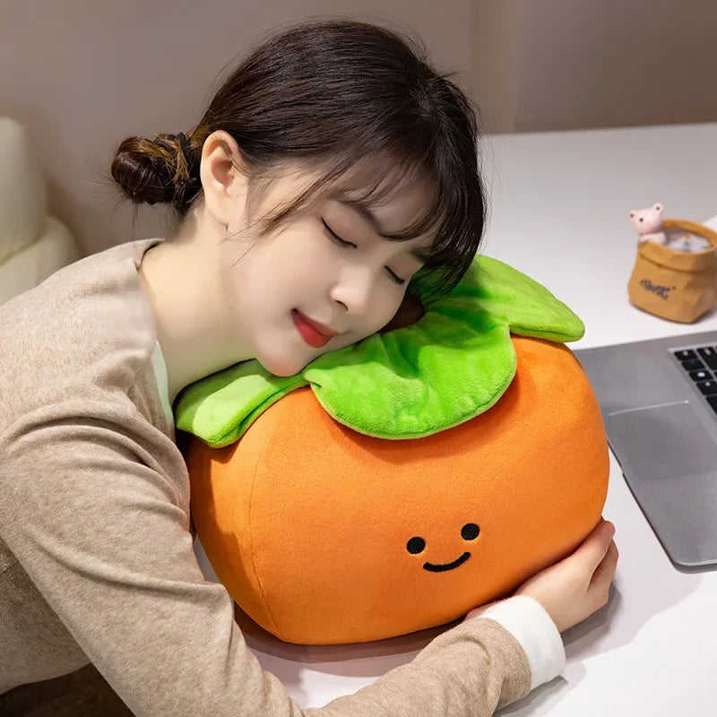 Person using a kawaii plush peach-shaped pillow at a desk with a laptop.