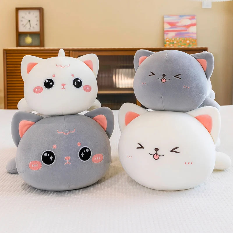 Four cute cat-shaped kawaii plush toys stacked on a bed.